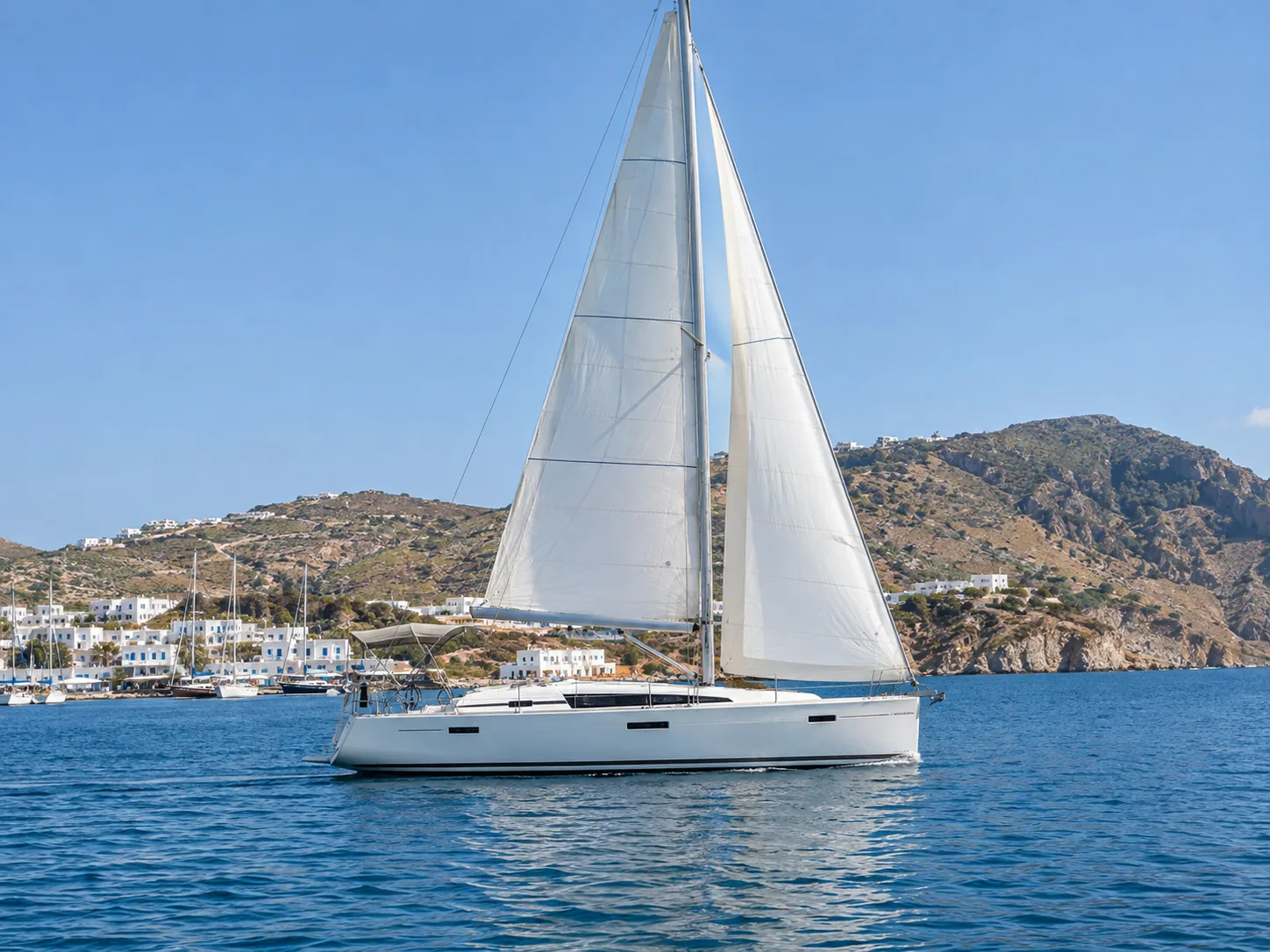 White sailing yacht under sail off a Greek island